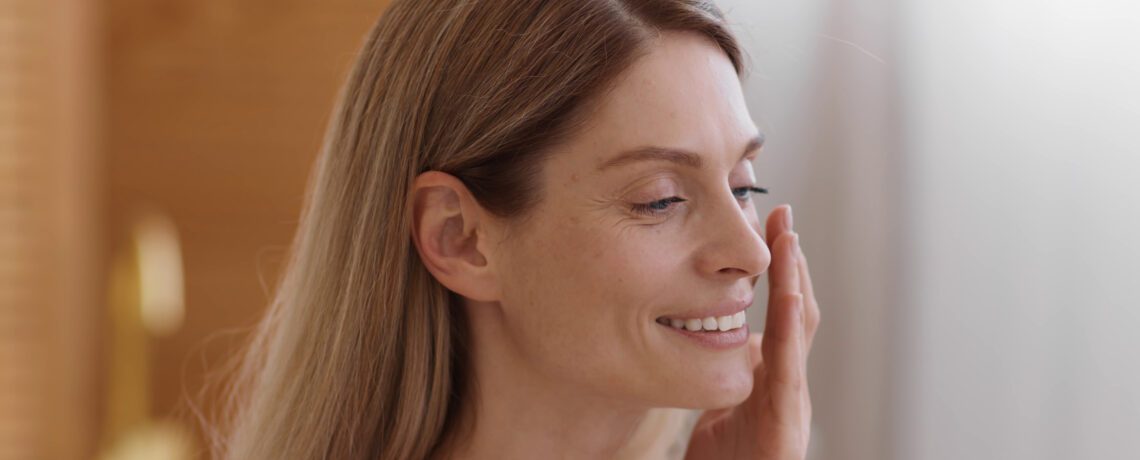 close up portrait of middle aged lady touching her face enjoying her smooth skin free SBI 351593257